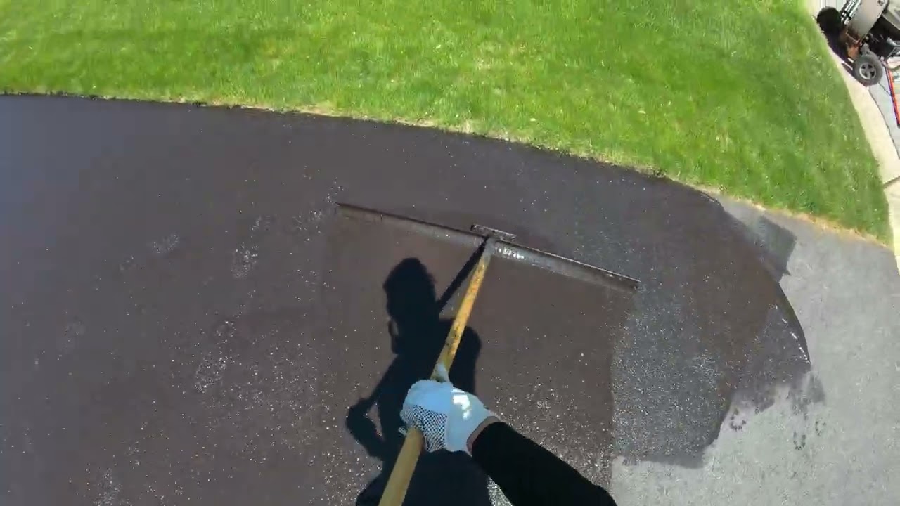 Crew applying sealcoat to an asphalt surface